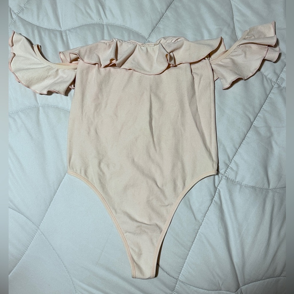 Baby pink thong off the shoulder ruffled bodysuit.